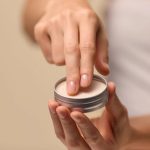 Hand som håller burk med kräm